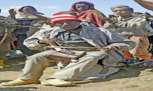 Zdjcie ETIOPIA / Amhara  / Gry Simien / 3,Na kamieniu, siedzia azmaris, wdrujcy etiopski trubadur w otoczeniu dzieci.