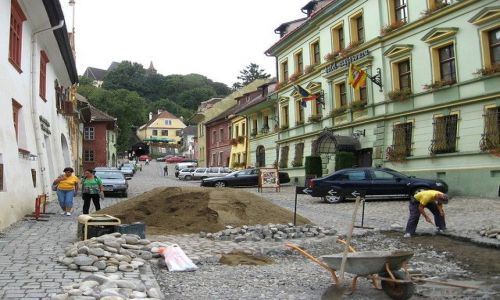 Zdjecie RUMUNIA / Transylwania / Sighisoara /  naprawa, w tle  koci na wzgrzu