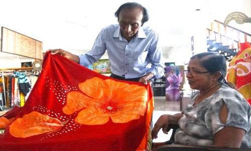 SRI LANKA / Kolombo / Studio batiku w Marawila / Eric Suriyasena prezentuje sari lubne, tkanin batikow dekorowan perekami i cekinami